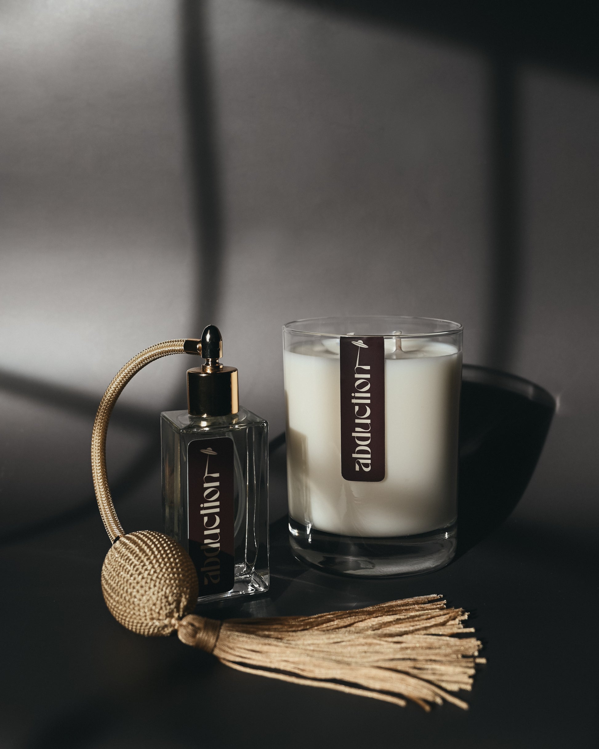 Vintage perfume bottle and candle on a dark surface