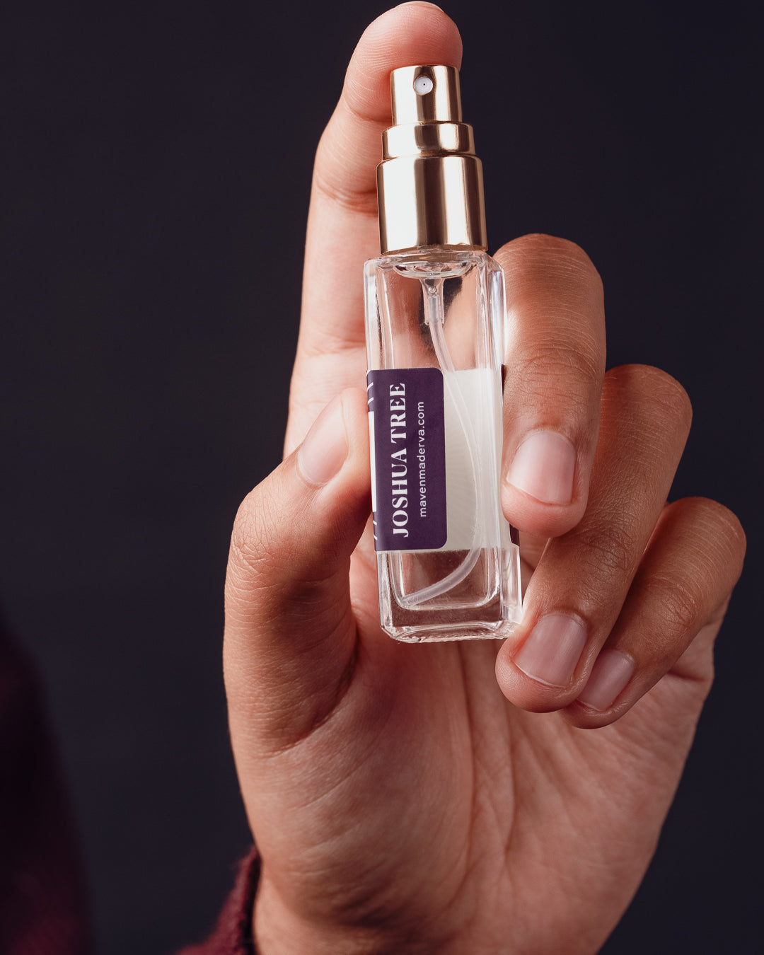 small square perfume bottle in hand