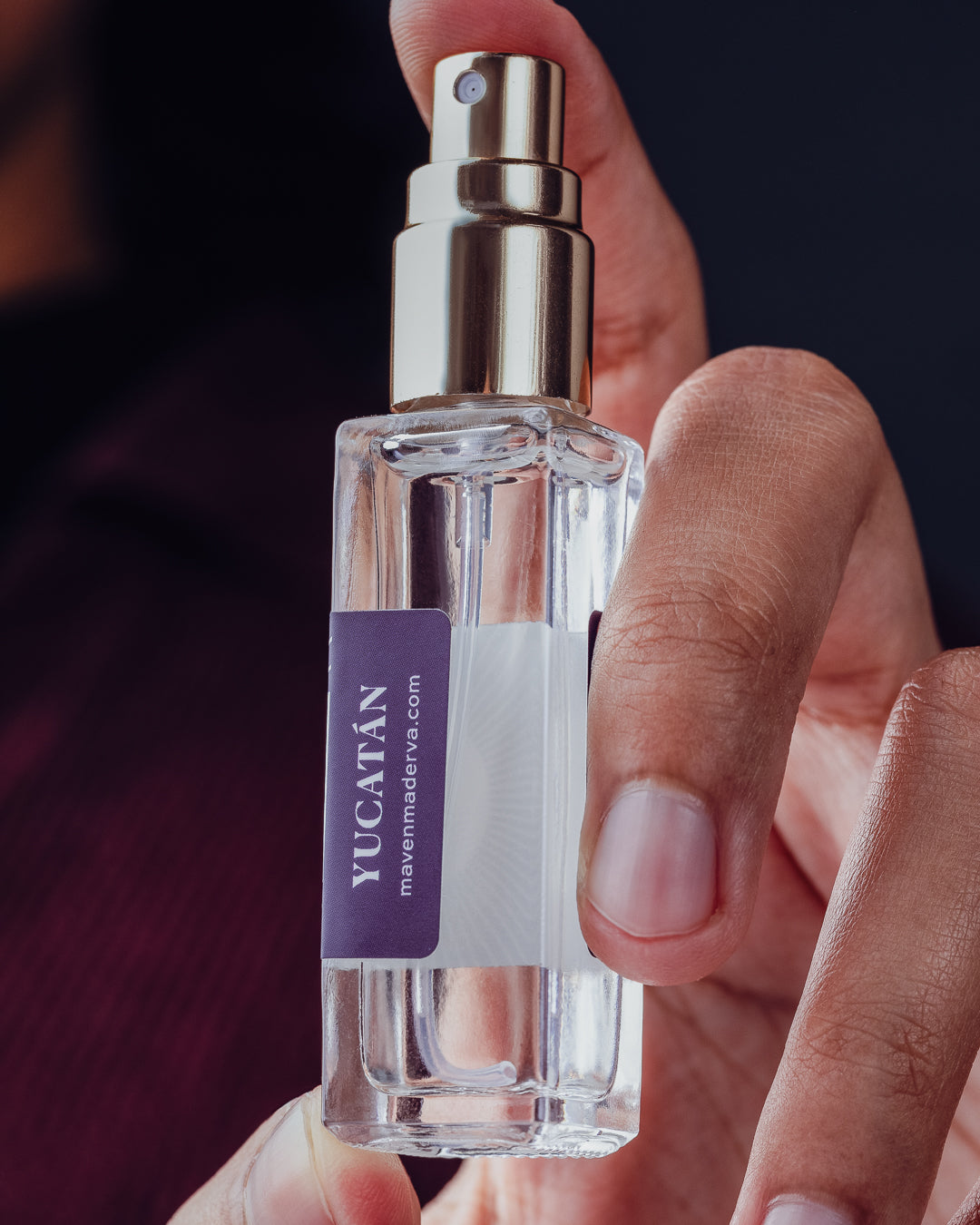 hand holding travel size perfume