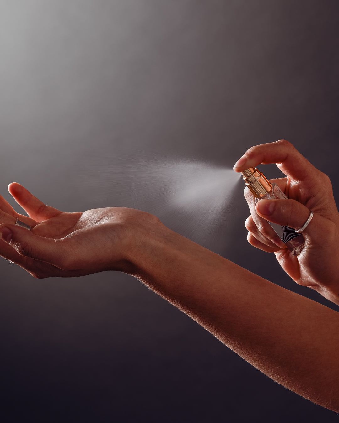 hand misting small perfume bottle on wrist